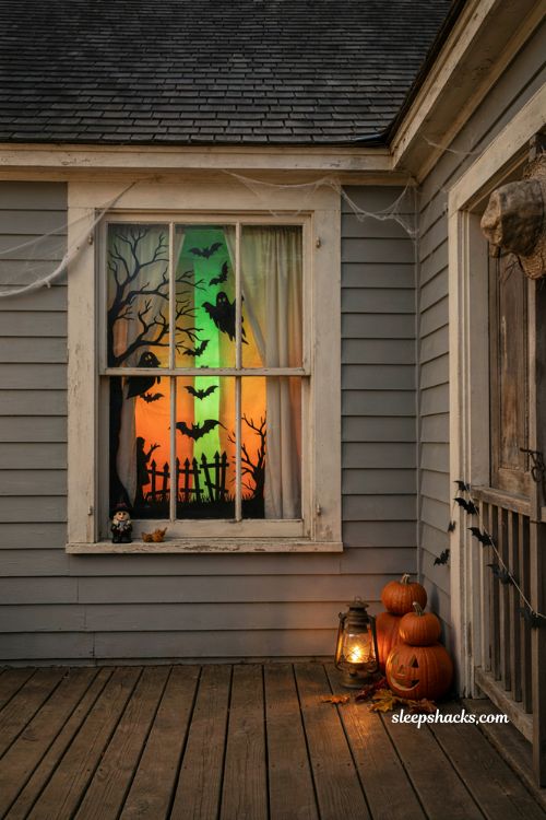 Black light Halloween window silhouettes with glowing green and orange poster board 