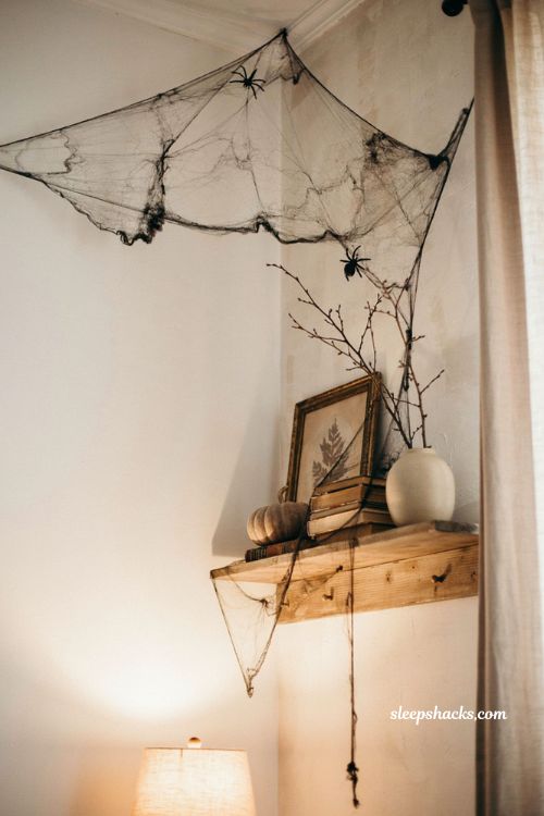 Black spiderweb Halloween decor draped across a bright cozy living room 