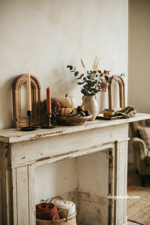 Boho fall mantel decor with distressed arches aged candle holders pumpkins and dried florals