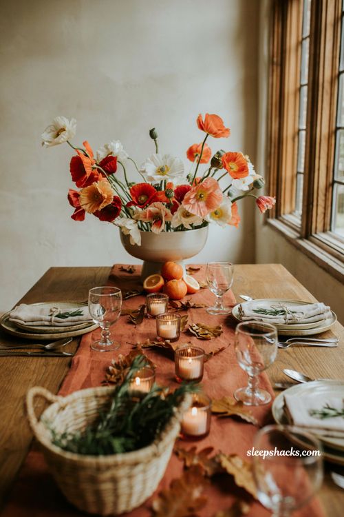 Bright poppy pedestal centerpiece arrangement in coral and cream for a cozy fall baby shower table