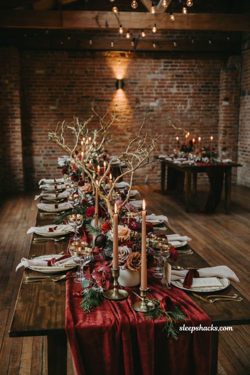 Burgundy and gold winter wedding decor with candles dark wood and elegant tablescape