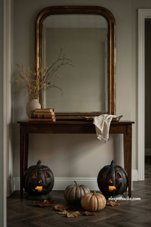Cast iron pumpkin candle holders with warm glow and vintage Halloween entryway decor