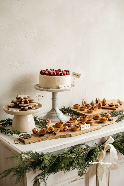 Charming holiday dessert table setup with tiered cake stands pine garland and handwritten tags for christmas