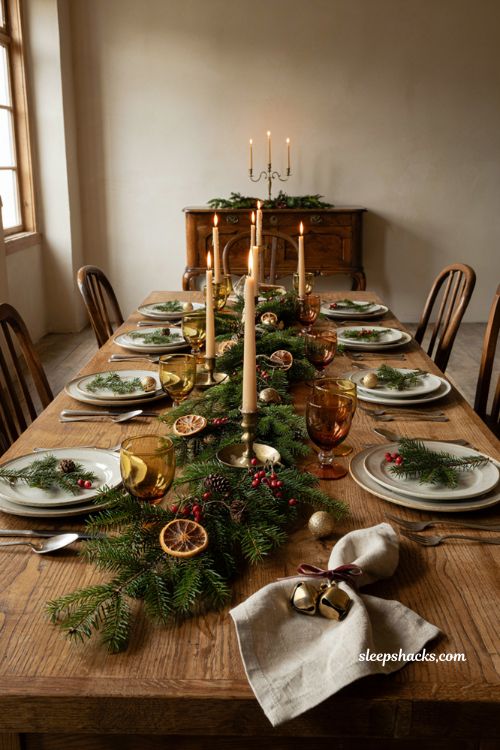 Christmas tablescape with bell tied napkin rings linen napkins and evergreen decor