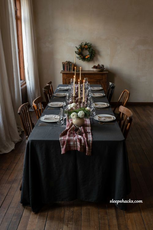Christmas tablescape with black tablecloth white flowers tartan runner and gold accents
