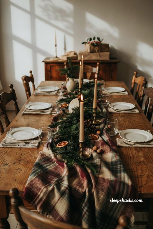 Christmas tablescape with clove studded orange pomanders greenery and candles