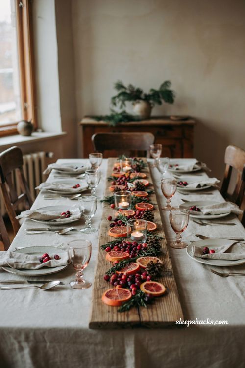 Christmas tablescape with fresh blood oranges cranberries rosemary and candle centerpiece