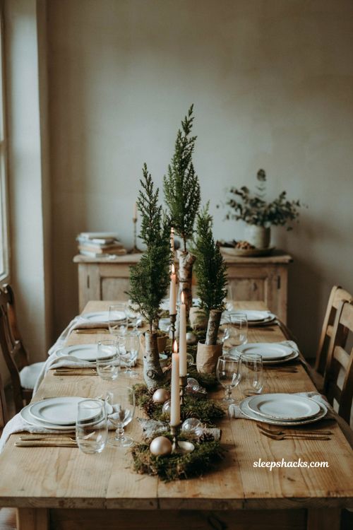 Christmas tablescape with mini tabletop trees moss glass ornaments and greenery