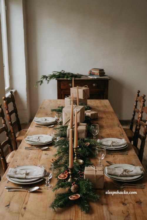 Christmas tablescape with wrapped presents evergreen garland and rustic table decor