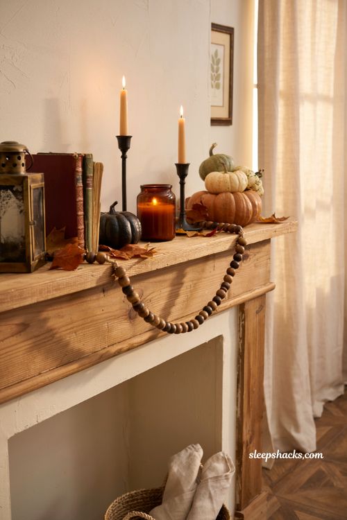 Classic cinnamon nutmeg pumpkin candle with cozy Halloween mantel decor in a farmhouse living room