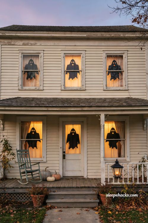 Classic ghost cutout Halloween window silhouettes on a cozy front porch 