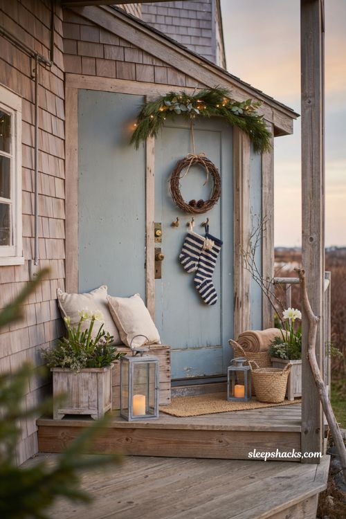 Coastal christmas porch decor ideas with navy striped stockings by the front door
