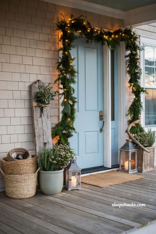 Coastal christmas porch decor ideas with distressed driftwood welcome sign and greenery