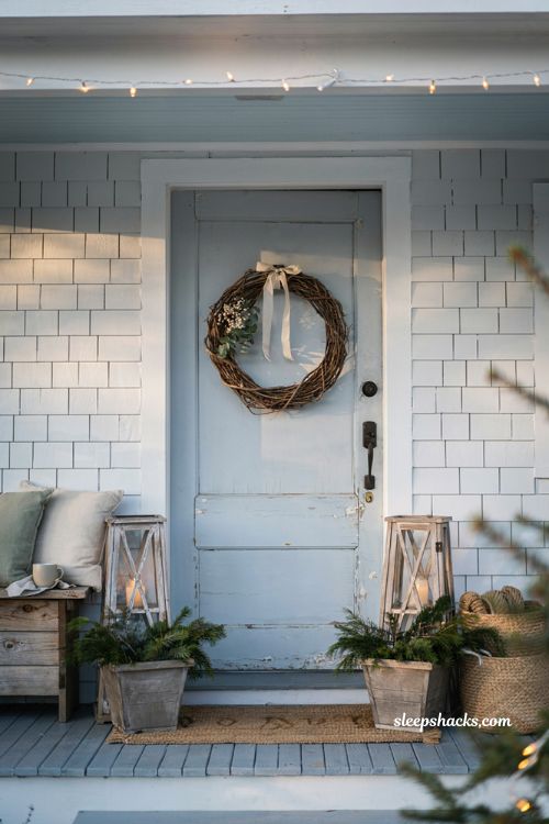 Coastal christmas porch decor ideas with minimalist grapevine wreath on blue front door