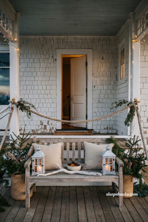 Coastal christmas porch decor ideas with nautical rope garland and cozy holiday lighting