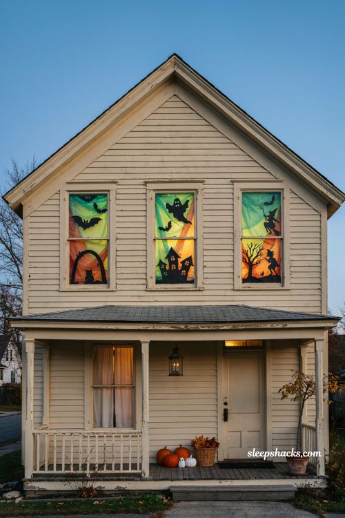 Colored tissue paper Halloween window silhouettes with glowing green and orange light 