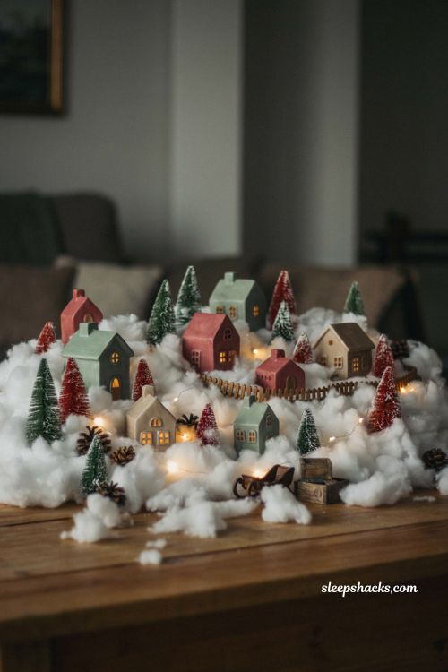 Cotton ball snow drift Christmas village display with fluffy handmade snow and glowing twinkle lights 
