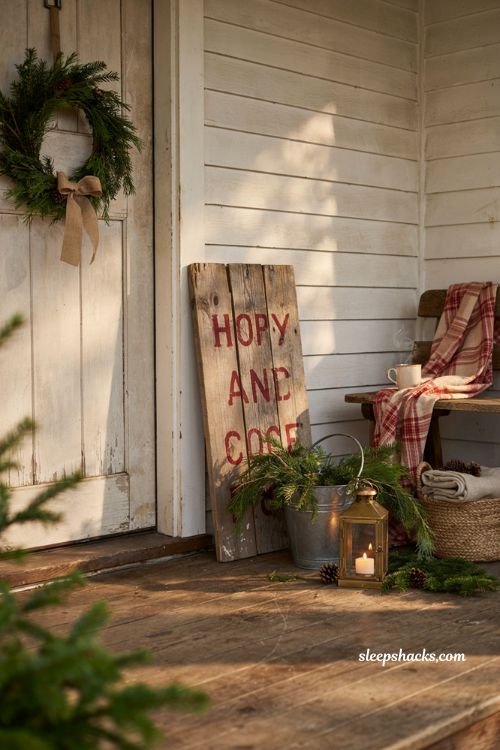 Country christmas porch with rustic hand painted wood sign and farmhouse holiday decor