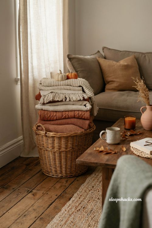 Cozy blanket basket with fall throw blankets pumpkins and warm living room decor