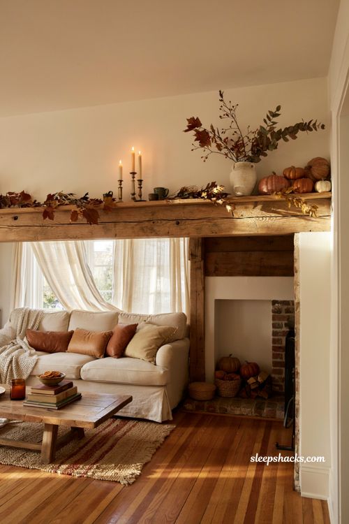 Cozy fall mantel display ideas with pumpkins candles and dried autumn garland