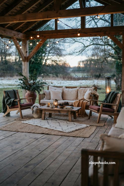 Cozy outdoor winter wedding lounge with rugs cushions blankets string lights and heaters