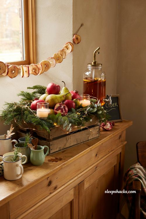 Cozy rustic fall baby shower cider station centerpiece idea with apple crate and dried apple garland