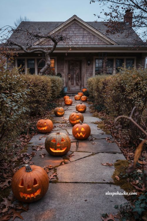 Creepy Halloween decorations with eerie jack o lanterns and glowing LED candles along a walkway 