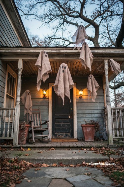 Creepy Halloween decorations with handmade cheesecloth ghosts hanging from a porch and tree 