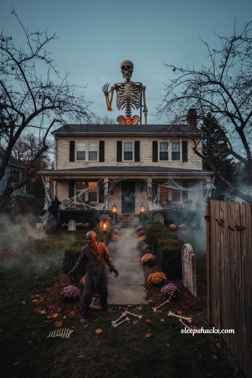 Creepy Halloween decorations with towering animatronic skeletons zombies fog and haunted yard lighting 