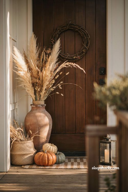Dried wheat and pampas grass fall entryway decor with rustic urn pumpkins and raffia