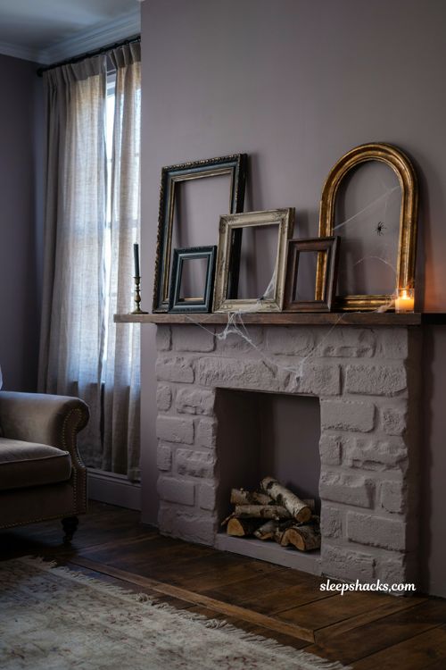 Empty vintage frames and cobwebs for eerie minimalist Halloween mantel decor