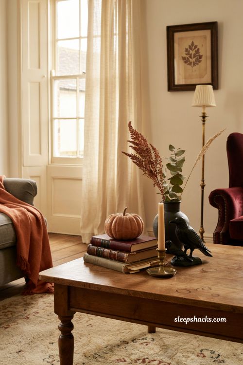 Fall Halloween coffee table decor with stacked vintage books and pumpkin topper