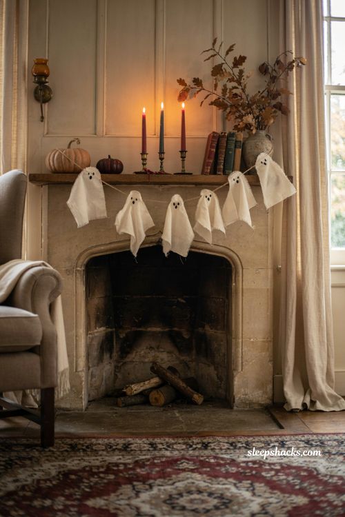 Fall Halloween mantel decor with fabric ghost garland and black taper candles