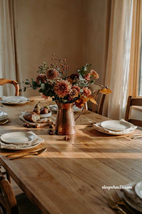 Fall centerpiece with aged copper pitcher and warm seasonal flowers