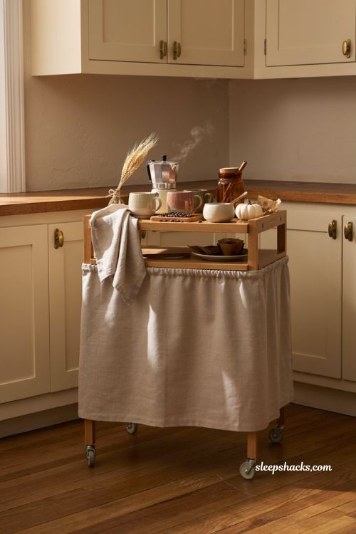 Fall coffee bar decor ideas with fabric cabinet skirt hidden coffee maker and cozy neutral accents 