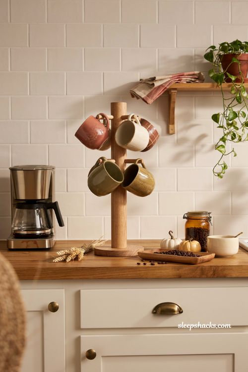 Fall coffee bar decor ideas with wooden mug tree warm pumpkin mugs and cozy seasonal accents 
