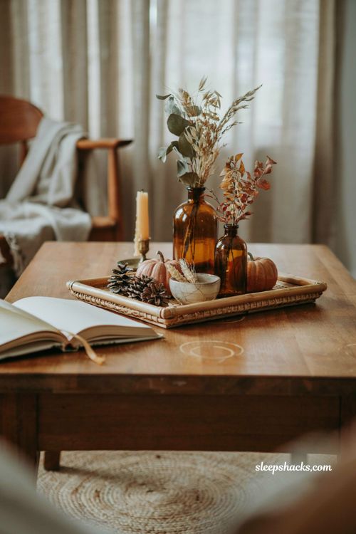 Fall coffee table decor tray with amber glass bottles dried stems and earthy accents