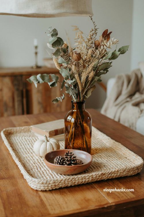 Fall coffee table decor tray with oversized dried greenery and amber glass bottle