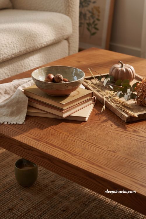 Fall coffee table decor with handmade ceramic pottery stacked books acorns and rustic seasonal accents 