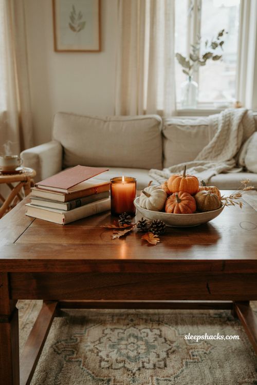 Fall coffee table decor with pumpkins books candle and cozy autumn styling