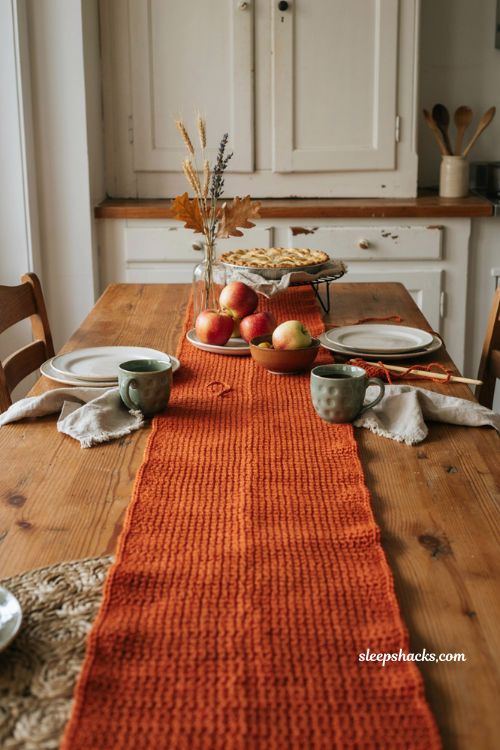 Fall crochet table runner patterns free with pumpkin orange yarn handmade crochet stitches rustic dining table and cozy autumn decor 