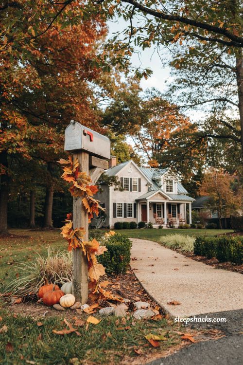 Fall mailbox decor with maple leaf garland mini pumpkins and rustic post