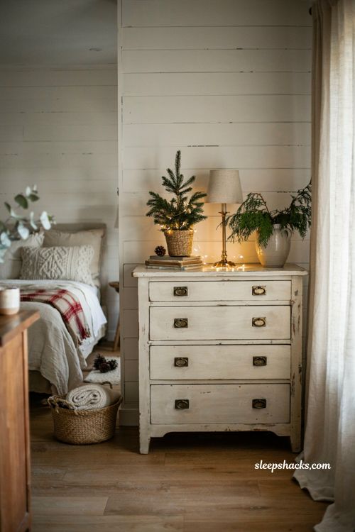 Farmhouse christmas bedroom with a mini tabletop tree on a vintage dresser