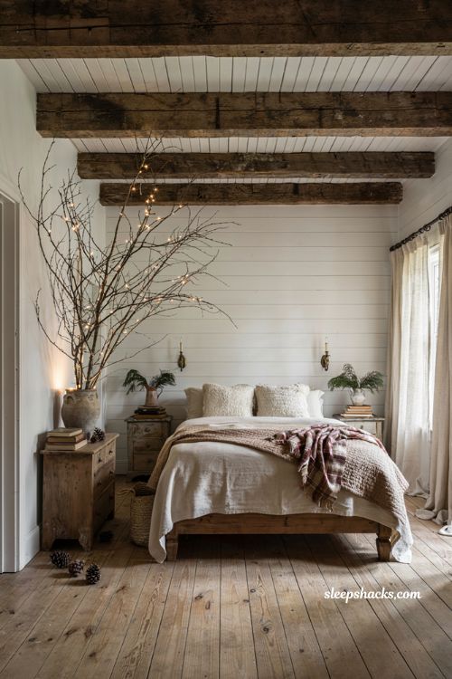 Farmhouse christmas bedroom with a pre lit branch spray creating a cozy winter focal point
