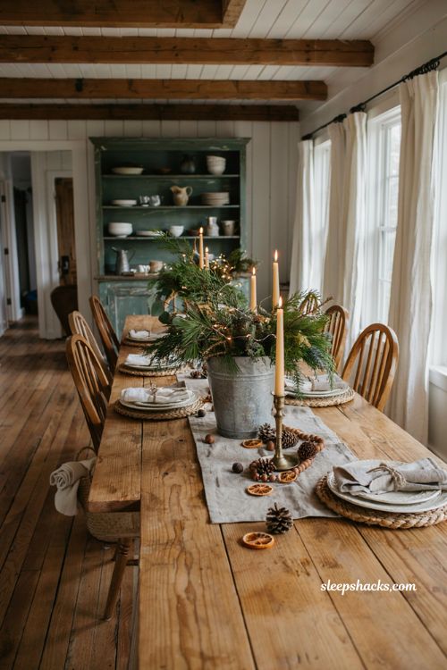 Farmhouse christmas dining table with a galvanized bucket filled with fresh holiday greenery