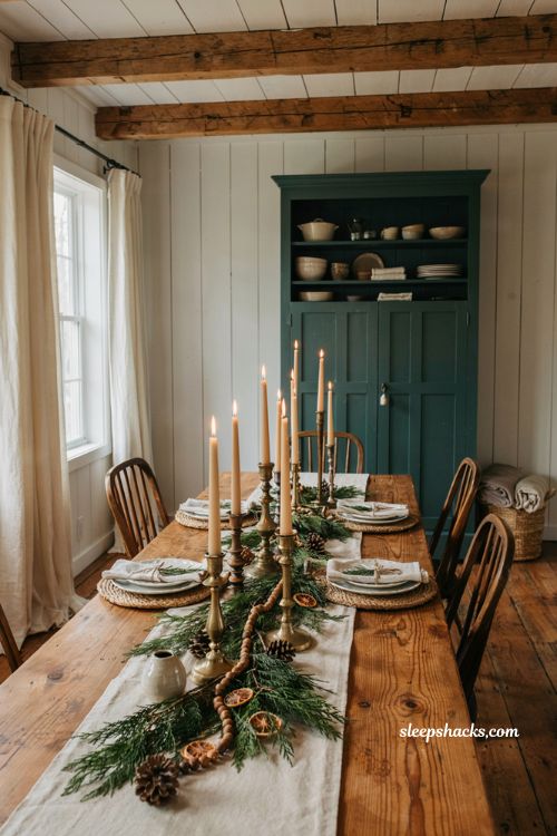 Farmhouse christmas dining table with mismatched aged brass candlesticks and greenery