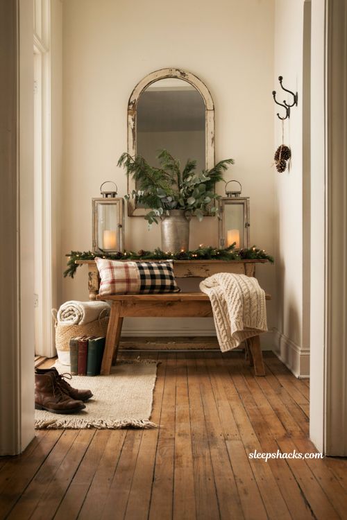 Farmhouse christmas entryway decor with cozy bench plaid pillows and knit throw