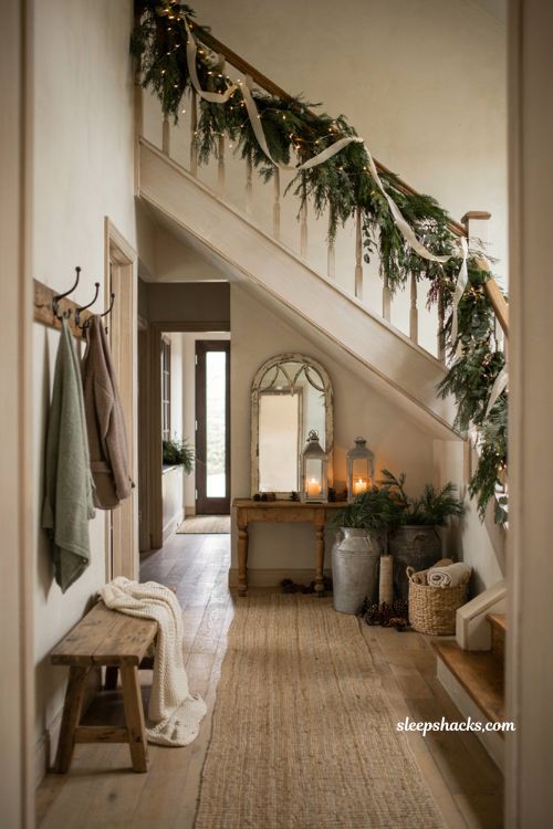 Farmhouse christmas entryway decor with draped garland along rustic staircase railing