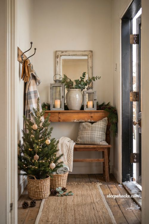 Farmhouse christmas entryway decor with mini christmas tree in woven basket by the door