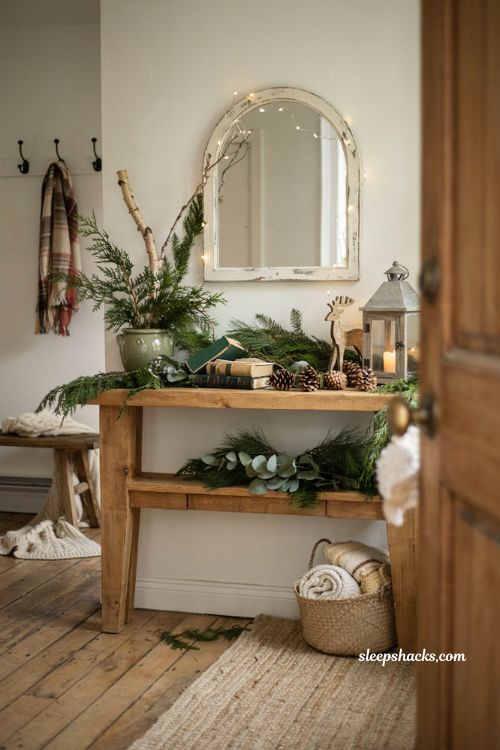 Farmhouse christmas entryway decor with rustic wooden reindeer and evergreen accents